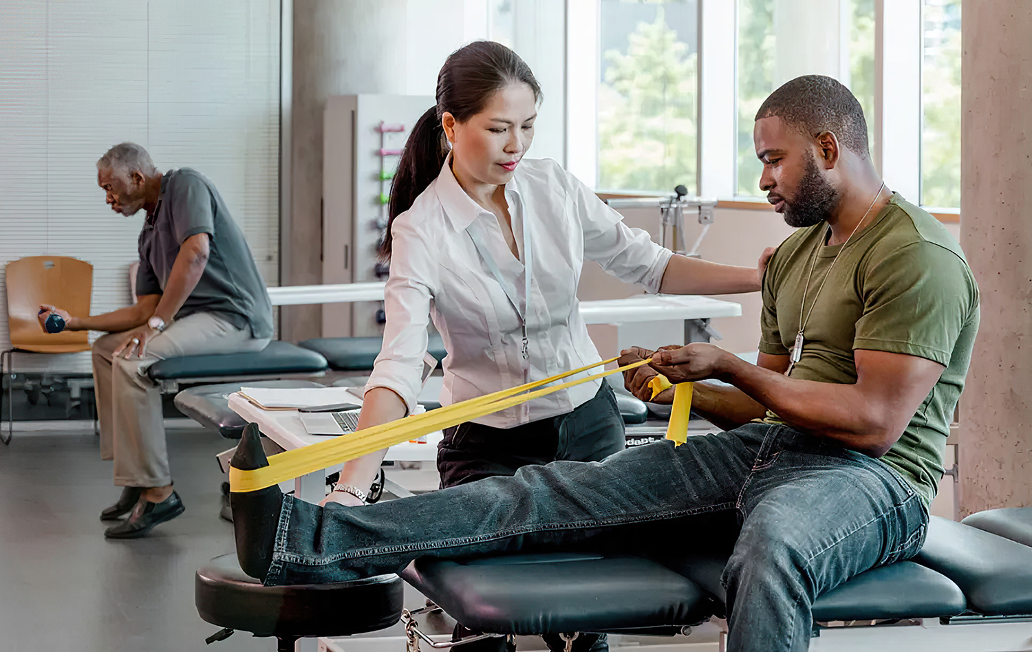 African-American-male-uses-a-yellow-resistance-band-in-rehab-center-1296x728-header-gigapixel-lines-scale-4_00x