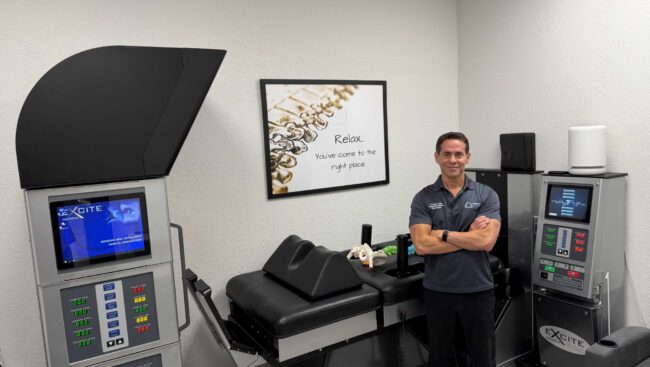 Dr. Steven Cantor, DC standing beside the DRX9000 spinal decompression system at TriMed Spine & Joint in Boca Raton
