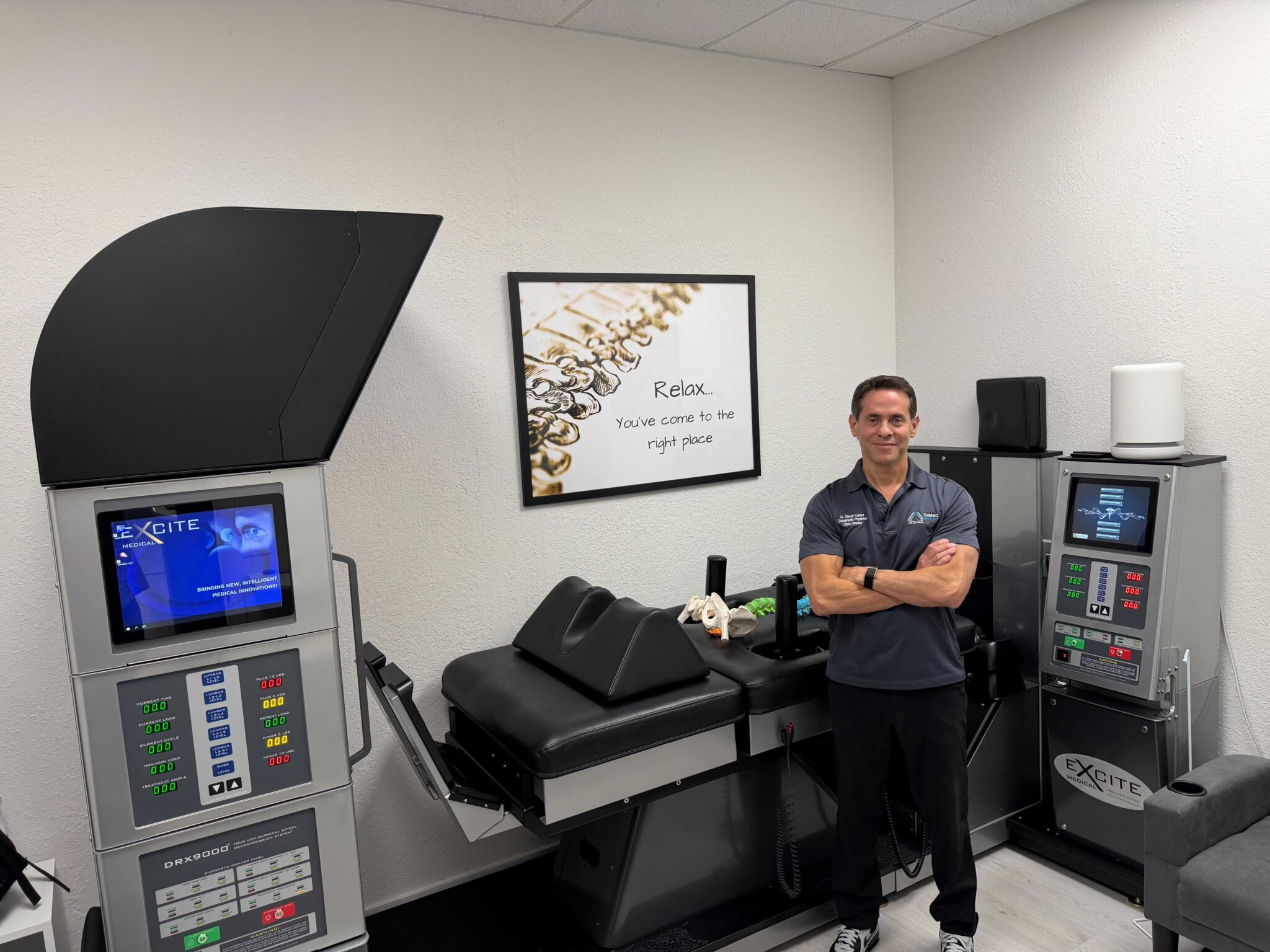 Dr. Steven Cantor, DC standing beside the DRX9000 spinal decompression system at TriMed Spine & Joint in Boca Raton